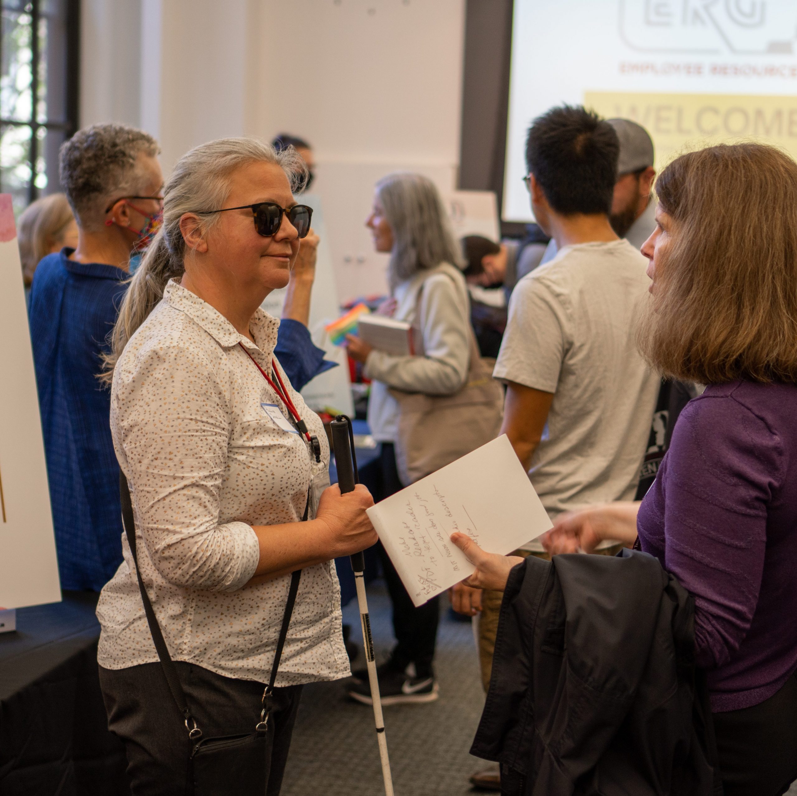 co-lead Pauline Dowell in conversation with another person at Welcome Wagon Event